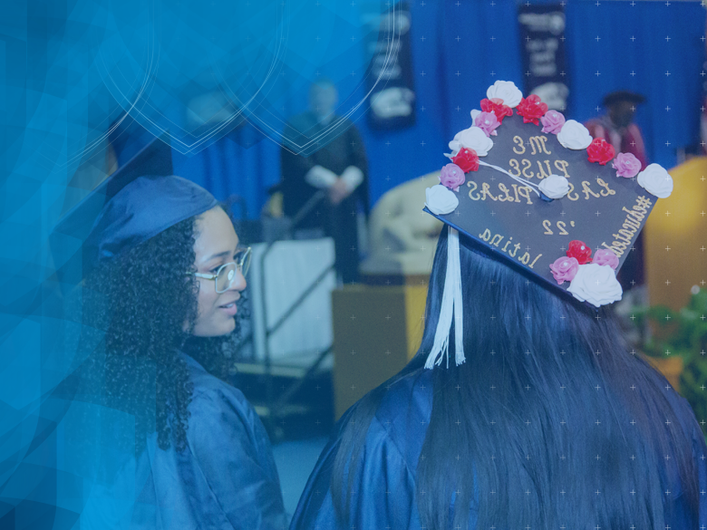 two female graduates in regalia at commencement 